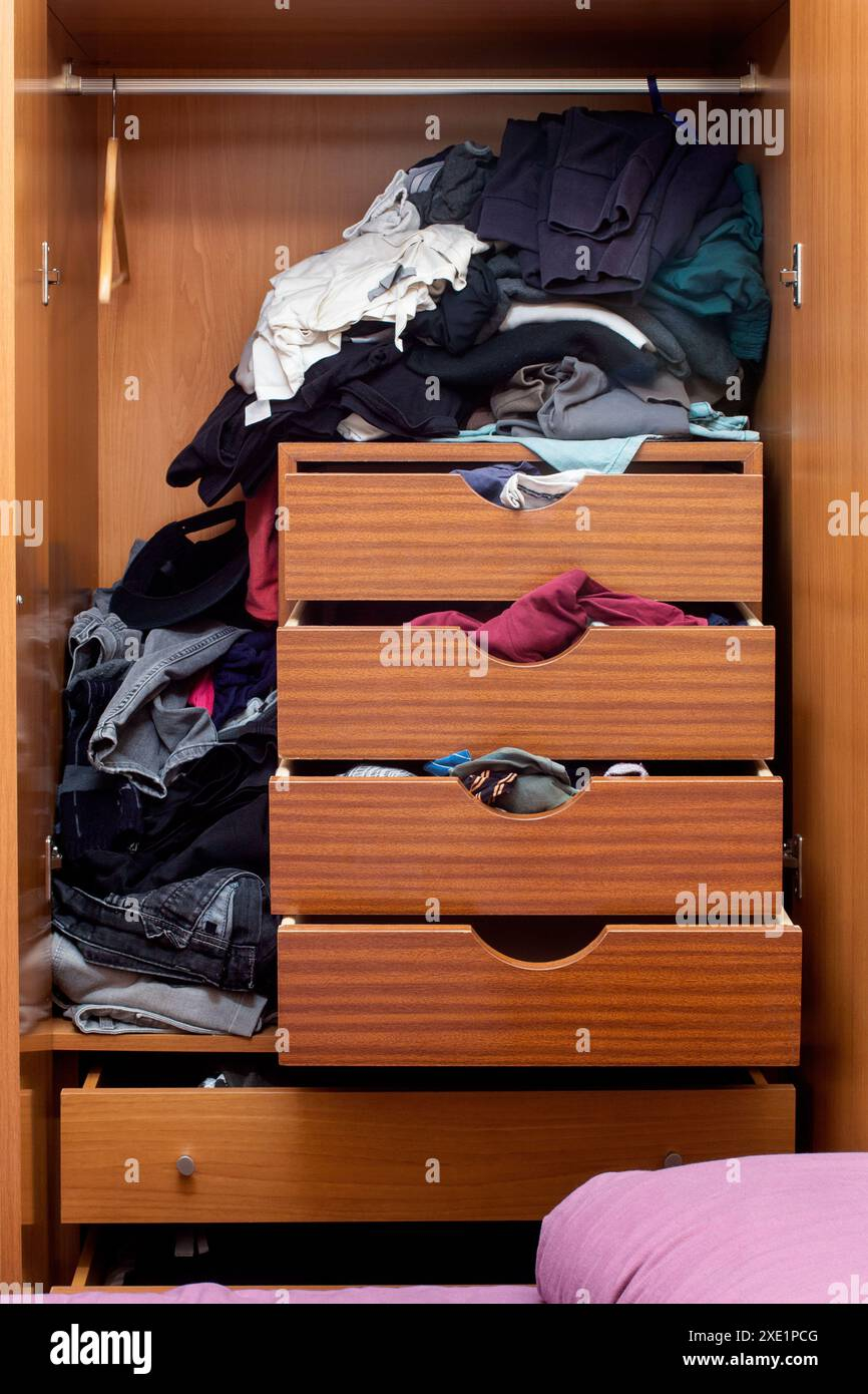 Cluttered Wooden Wardrobe With Disorganized Clothing - A Concept Of ... with