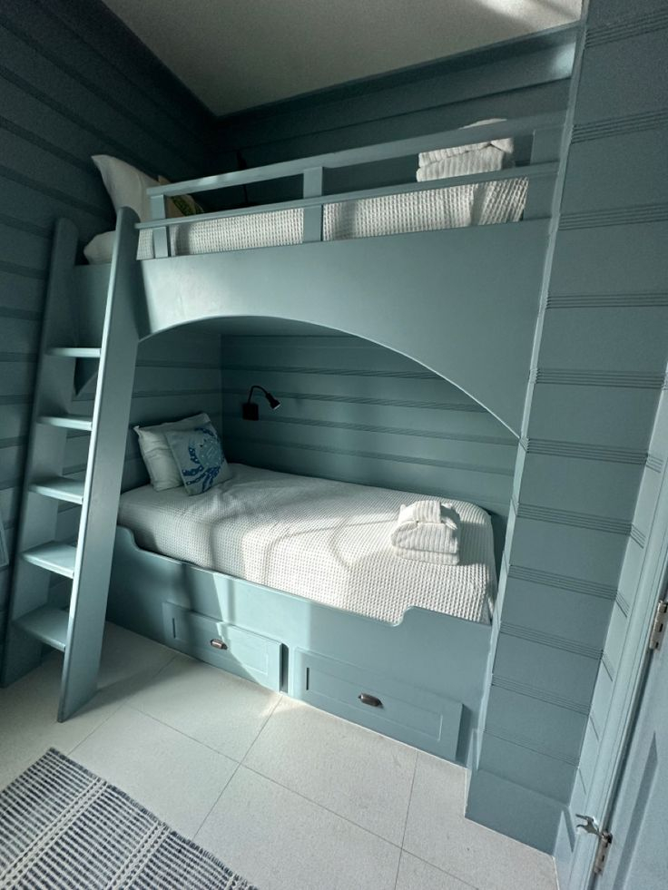 A Bunk Bed In A Room With Blue Walls And White Flooring On The Wall inside